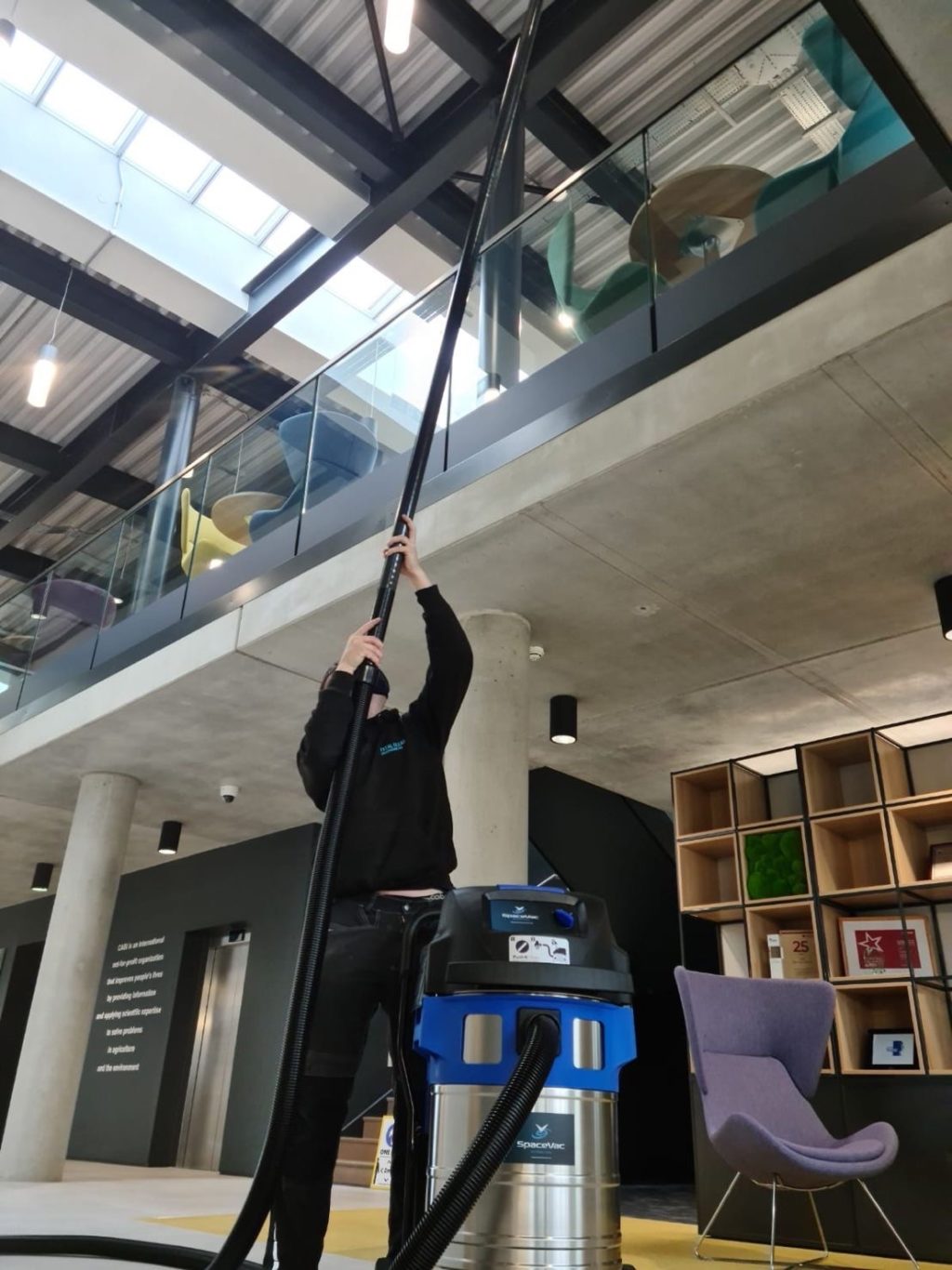 Man cleaning high ceiling with a SpaceVac vacuum